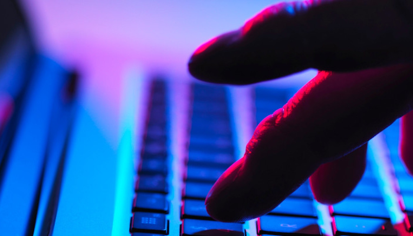 Hand typing on laptop