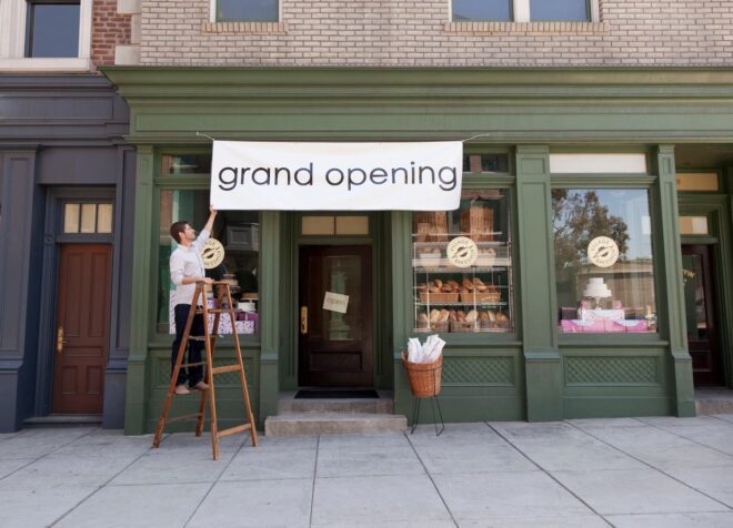 Man hanging grand opening banner