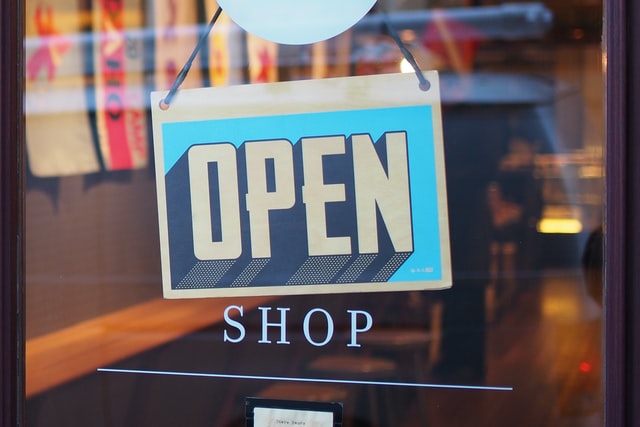 Open sign hanging in shop window