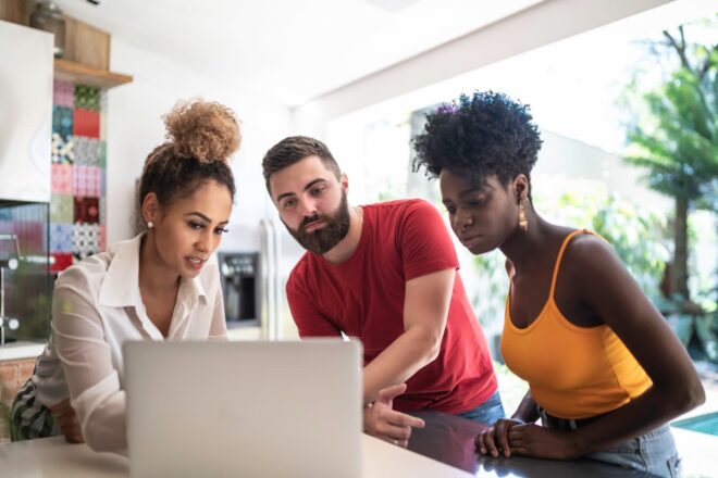 Three people looking at laptop