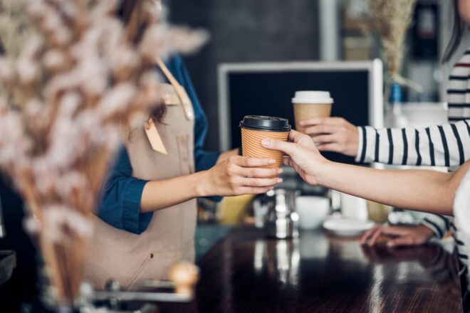 Hands exchanging to go cups