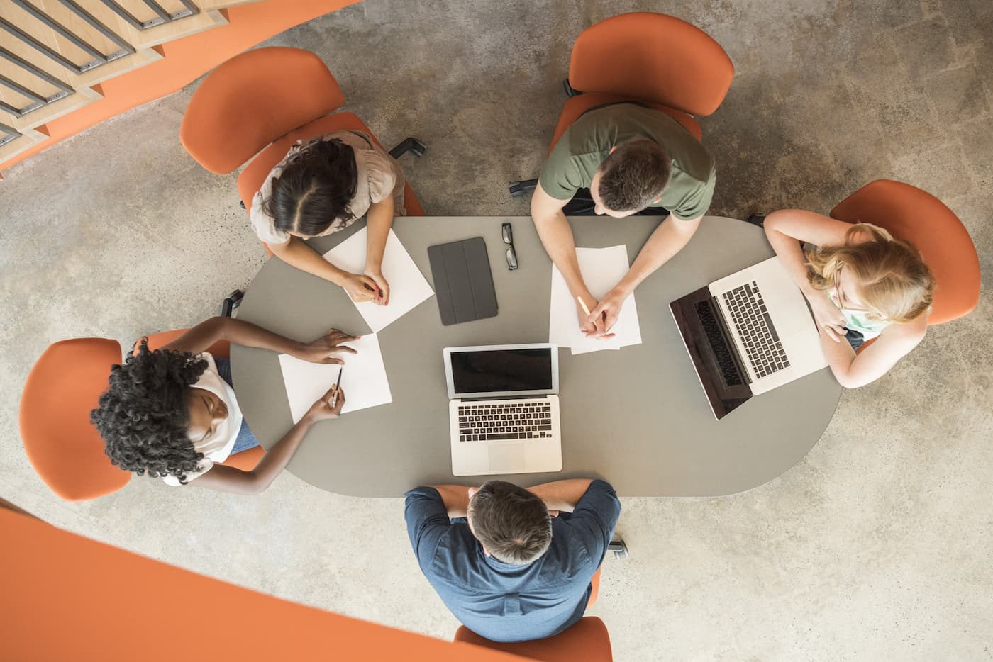 Overhead view of five people in meeting