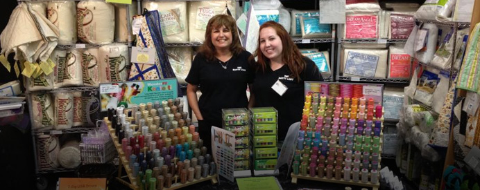 Batty Lady employees behind spools of thread