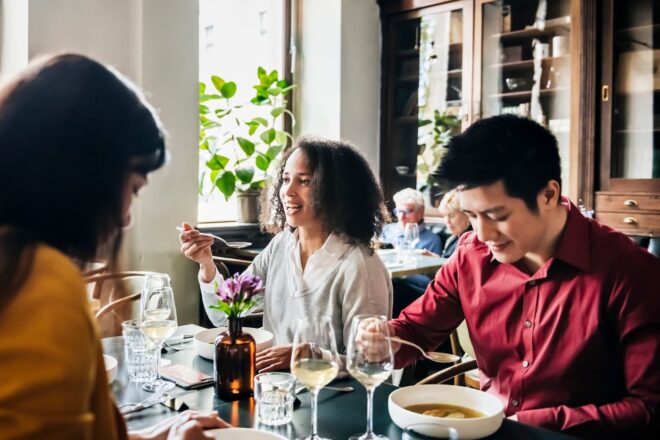 Three people eating ramen at a restaurant