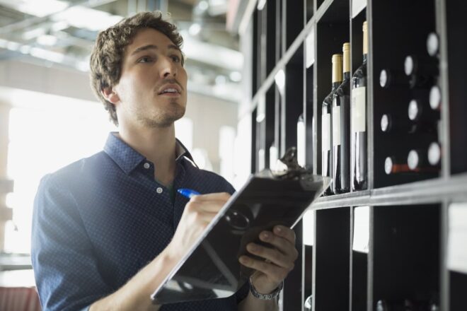 Man taking liquor inventory on clipboard