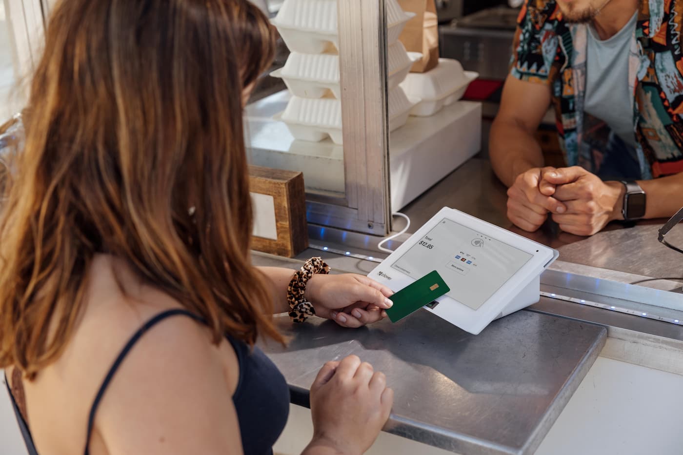 Woman holding card over Clover Mini at food stand