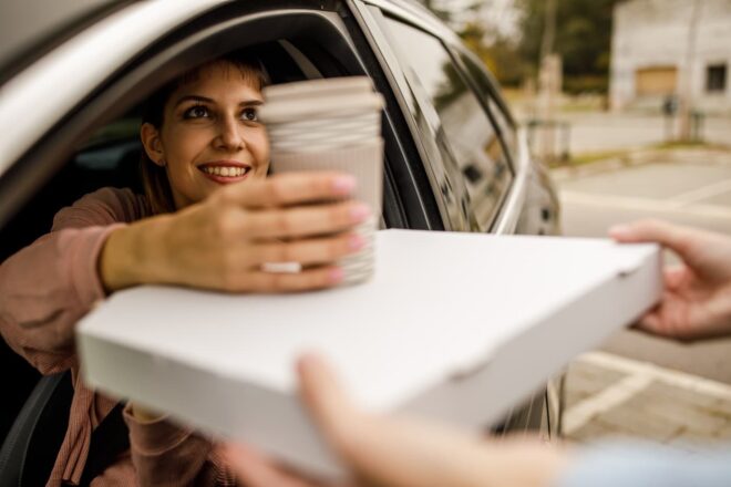 Woman picking up beverage in drive thru
