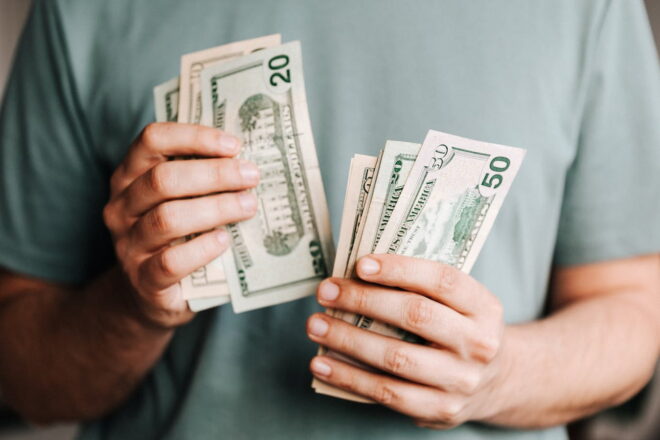 Man in green shirt holding cash