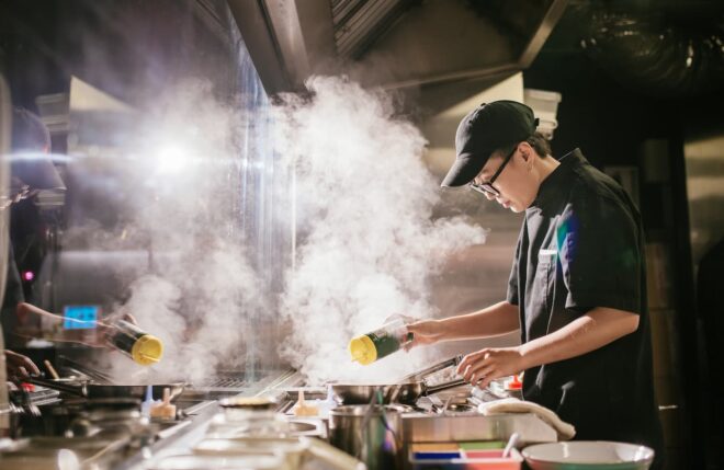 Chef adding seasoning to a pan